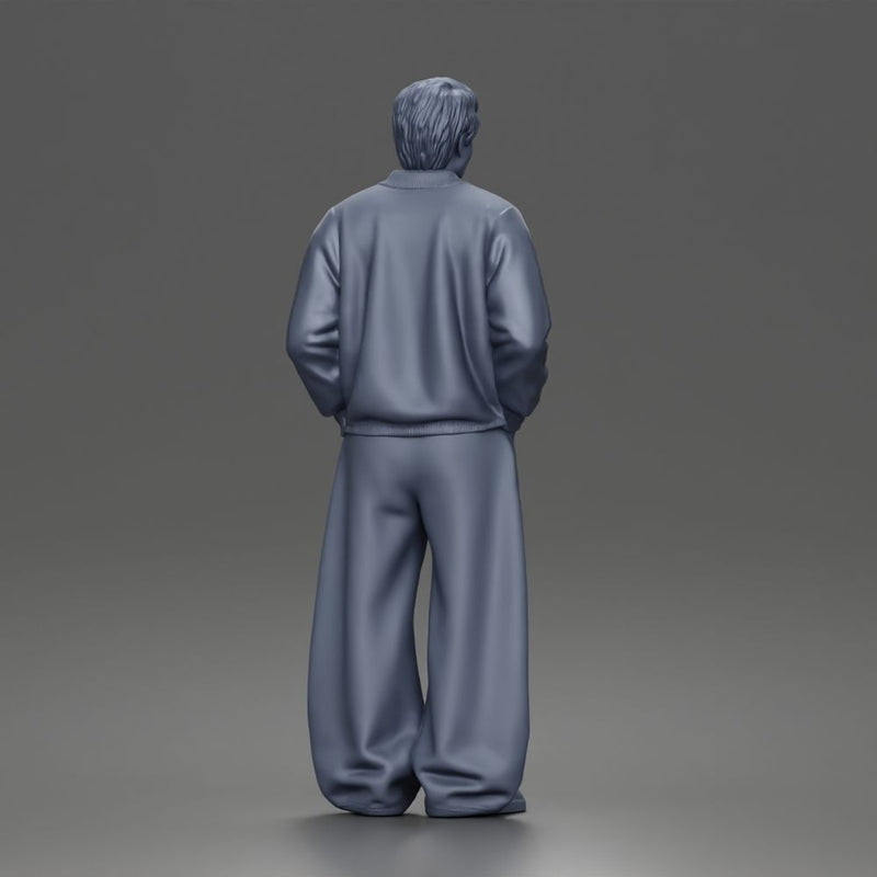 Urban male standing in varsity jacket and baggy trousers