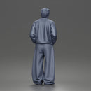 Urban male standing in varsity jacket and baggy trousers