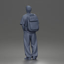Student standing with backpack wearing oversized tee and baggy jeans
