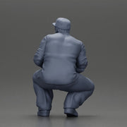 Gangster man crouching in a relaxed pose wearing casual clothing and cap - Only-Games
