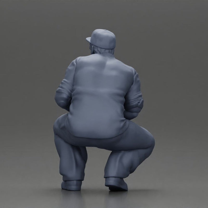 Gangster man crouching in a relaxed pose wearing casual clothing and cap - Only-Games