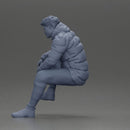 Street performer crouching low in blue puffer jacket athletic stance sitting - Only-Games