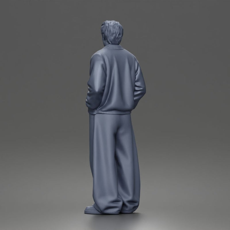 Urban male standing in varsity jacket and baggy trousers