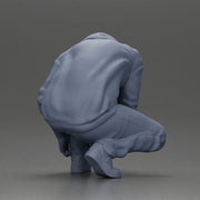 Man in hoodie crouching down tying shoelaces focused in casual outfit - Only-Games