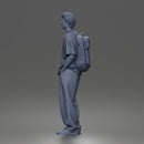 Student standing with backpack wearing oversized tee and baggy jeans