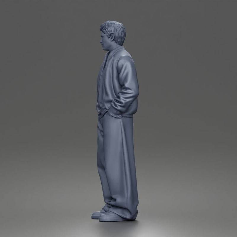 Urban male standing in varsity jacket and baggy trousers