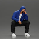 Thoughtful Man in Hoodie Squatting with Hand on His Face - Only-Games