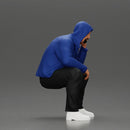 Thoughtful Man in Hoodie Squatting with Hand on His Face - Only-Games