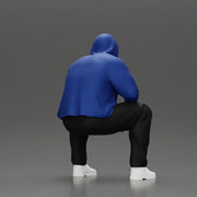 Thoughtful Man in Hoodie Squatting with Hand on His Face - Only-Games