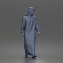 Walking man looking aside wearing traditional thobe headscarf and sandals