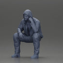 Thoughtful Man in Hoodie Squatting with Hand on His Face - Only-Games