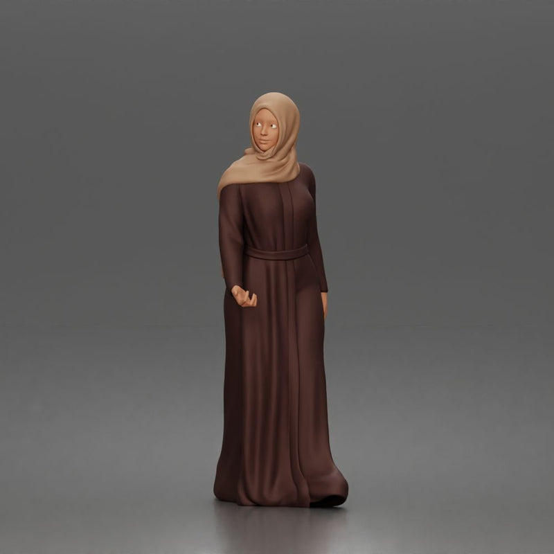 Standing woman looking aside wearing hijab and long belted abaya