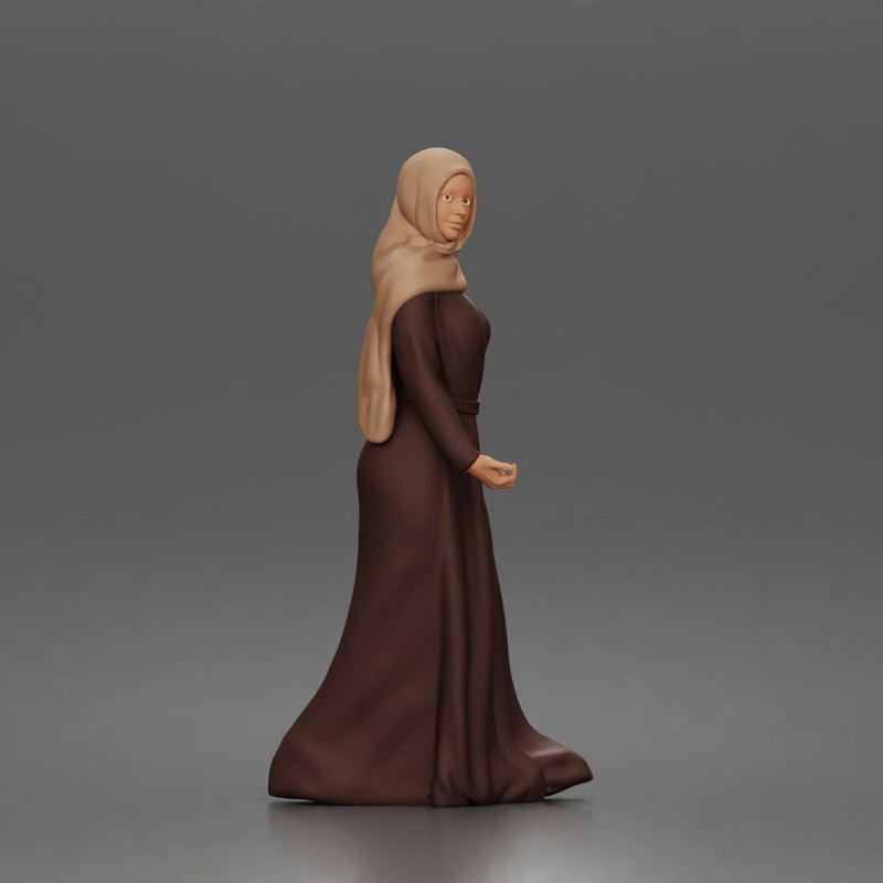 Standing woman looking aside wearing hijab and long belted abaya
