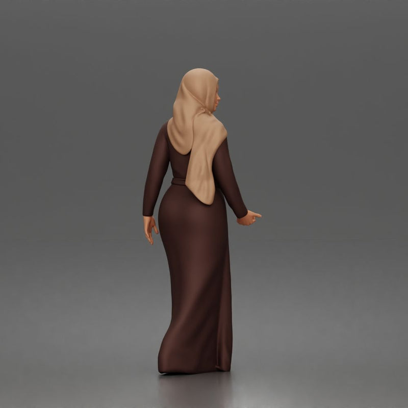 Standing woman looking aside wearing hijab and long belted abaya