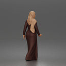 Standing woman looking aside wearing hijab and long belted abaya