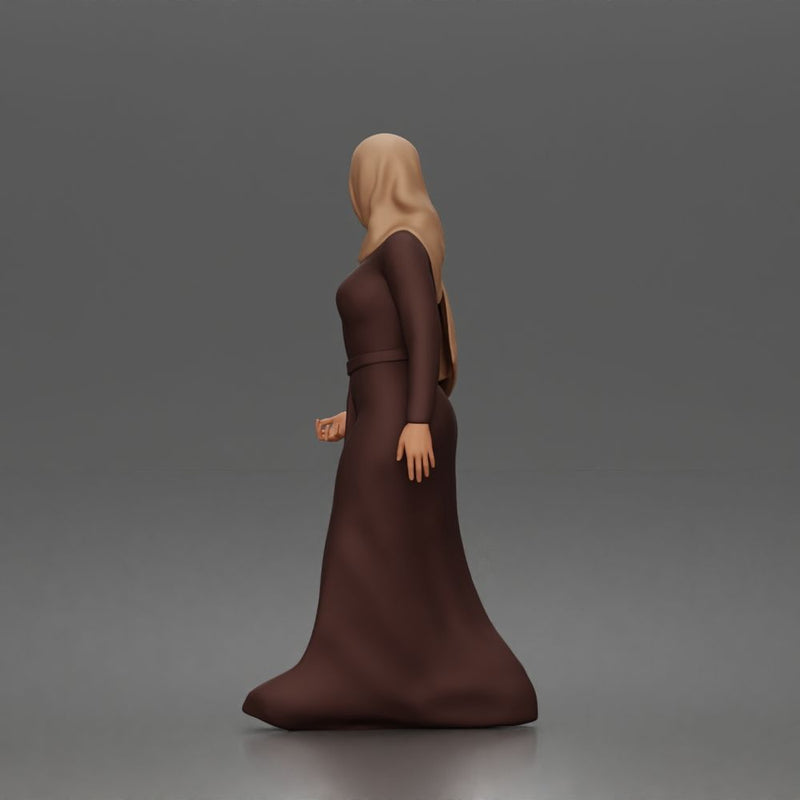 Standing woman looking aside wearing hijab and long belted abaya
