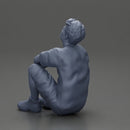 man sitting in shorts on the floor with hands on his knees - Only-Games