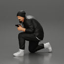 Gangster in hat and jacket sitting and holding a gun hides behind the car - Only-Games