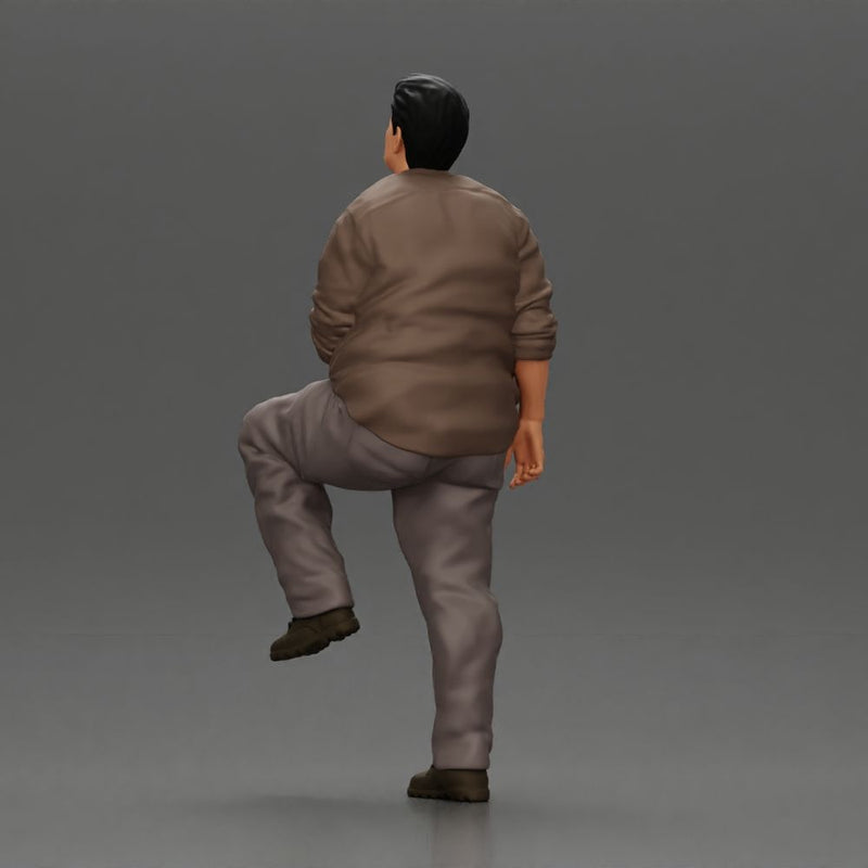 Fat Asian man looking upward in shirt and pants with one leg placed on a step