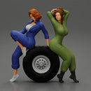 Two sexy girls in mechanic suits are sitting on a truck tire - Only-Games