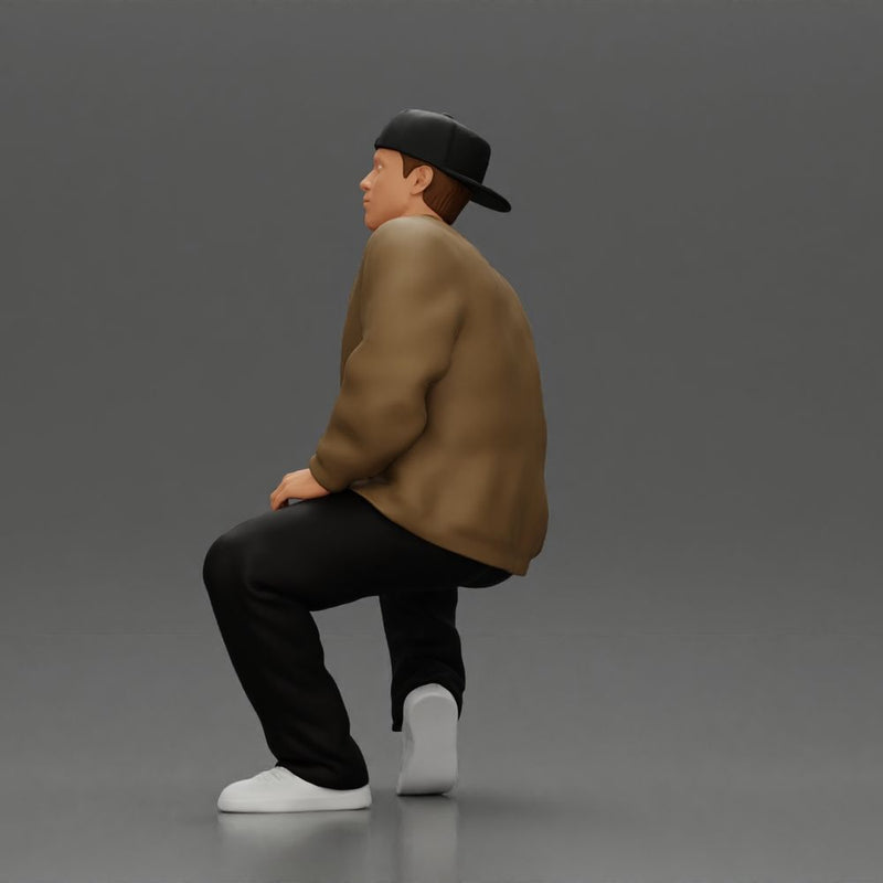 hip hop man sitting in a jacket and cap