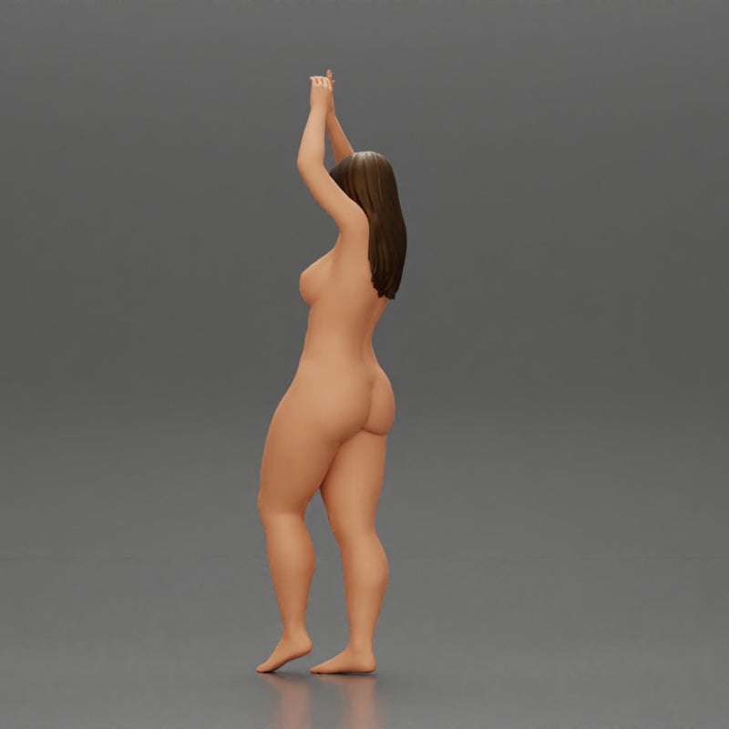 Naked woman standing with her arms raised up on the beach