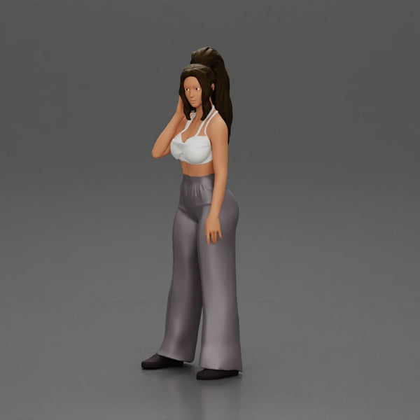 Stylish woman in a crop top and pants, standing thoughtfully