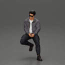 man sitting on a car, wearing a jacket and sunglasses, deep in thought - Only-Games