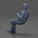 Man Sitting Wearing a Puffer Jacket, Holding a Coffee Cup - Only-Games