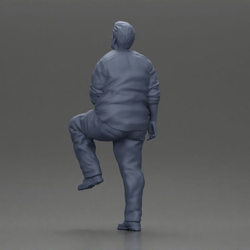 Fat Asian man looking upward in shirt and pants with one leg placed on a step