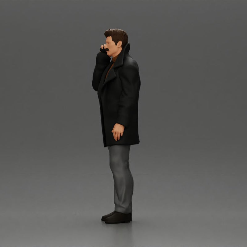 Turkish man in a coat with sweater standing talking on the mobile phone