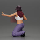 Young girl wearing a hat and pants sitting holding a sign and hitchhiking - Only-Games