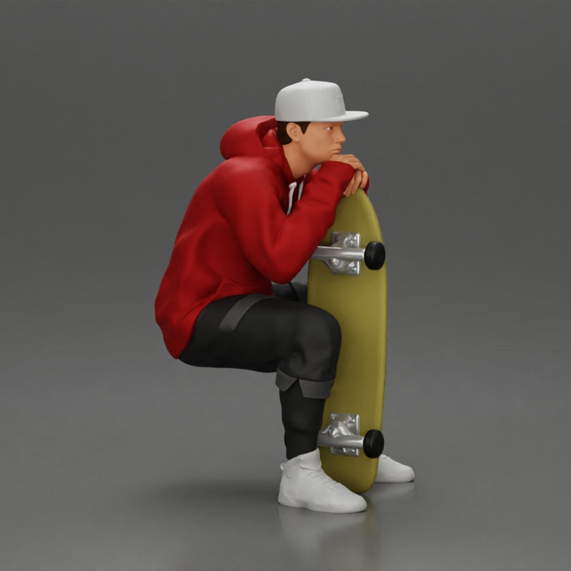 man in hoodie and cap sitting and putting his hand on the skateboard