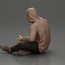 Contemplative man in hoodie sitting cross-legged, expressing curiosity thoughtfully - Only-Games