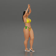 beautiful woman in a bikini with sunglasses standing with her arms raised up on the beach - Only-Games