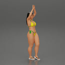 beautiful woman in a bikini with sunglasses standing with her arms raised up on the beach - Only-Games