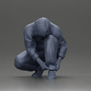 Worker injumpsuit Squatting Down, Carefully Adjusting His Pants with Focus - Only-Games