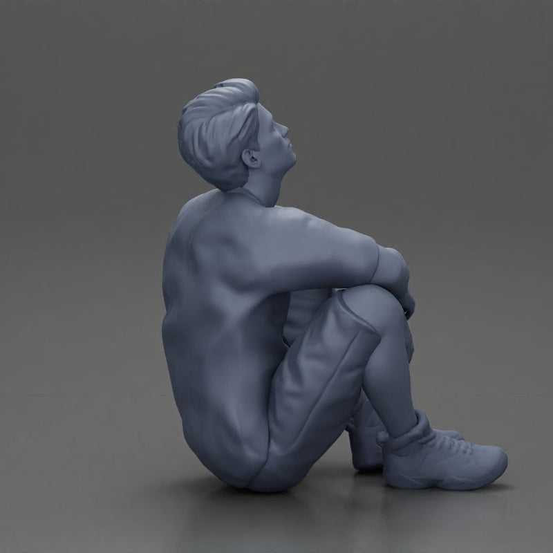 man sitting in shorts on the floor with hands on his knees - Only-Games