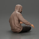 Contemplative man in hoodie sitting cross-legged, expressing curiosity thoughtfully - Only-Games