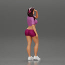 young woman in shorts and headphones shields her eyes from the sunlight - Only-Games