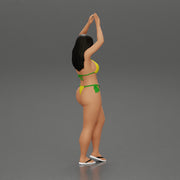 beautiful woman in a bikini with sunglasses standing with her arms raised up on the beach - Only-Games