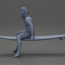 Long-Haired Surfer Sitting on a Surfboard in Calm Ocean Waters, Waiting for the Waves - Only-Games