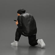 Gangster in hat and jacket sitting and holding a gun hides behind the car - Only-Games