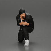 Gangster in hat and jacket sitting and holding a gun hides behind the car - Only-Games