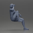 Young woman sitting on a chair hugging her pulled-up leg while drinking - Only-Games