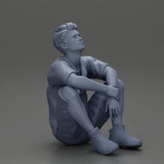 man sitting in shorts on the floor with hands on his knees - Only-Games