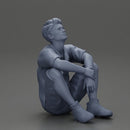 man sitting in shorts on the floor with hands on his knees - Only-Games