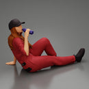 Tired woman mechanic in suit and cap sitting and drinking water during from bottle - Only-Games