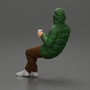Man Sitting Wearing a Puffer Jacket, Holding a Coffee Cup - Only-Games