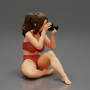 Woman photographer in bikini sitting and holding a camera - Only-Games
